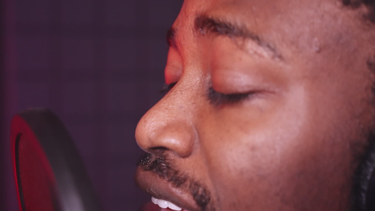 hombre cantando en el micrófono en el estudio de grabación