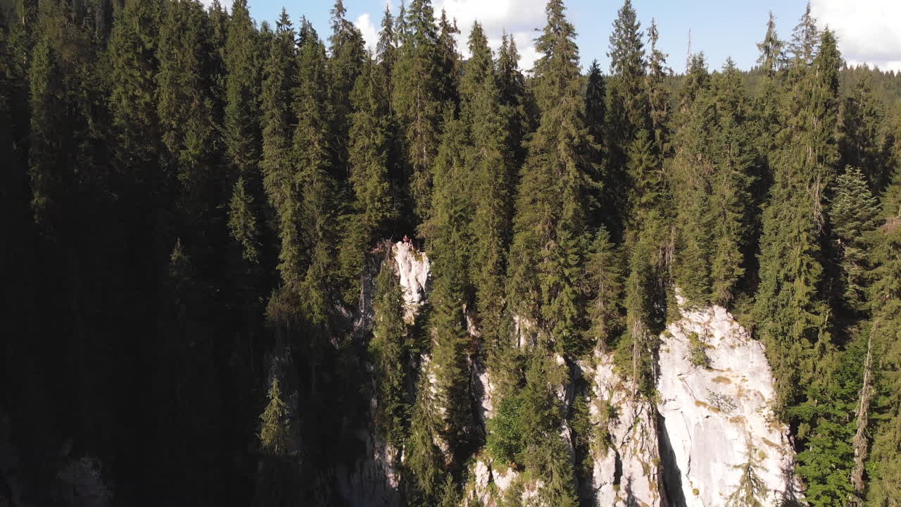Dramatic pullout aerial reveal of two hikers at Cetatile Ponorului Padis Transylvania Romania
