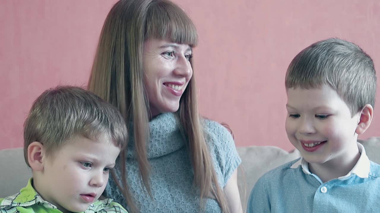 어머니 와 두 아들 이 태블릿 컴퓨터 2 를 가지고 놀고 있다