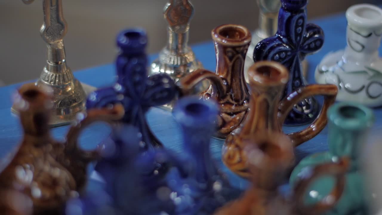 Handheld shot of blue and brown handcrafted ceramic candle holders on display.