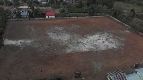 Side-panning-shot-of-people-playing-soccer-at-Indonesia,-aerial