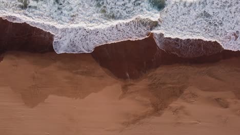 Olas-Del-Océano-índico-Golpeando-La-Playa-De-Illovo-En-Sudáfrica,-Subiendo-Tiro-De-Arriba-Hacia-Abajo