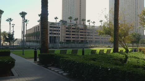 4K-Video:-Park-and-Train-Tracks-in-Foreground,-Parking-Garage-Next-to-Marriott-Hotel,-Cars-Driving-By,-Summer-2023