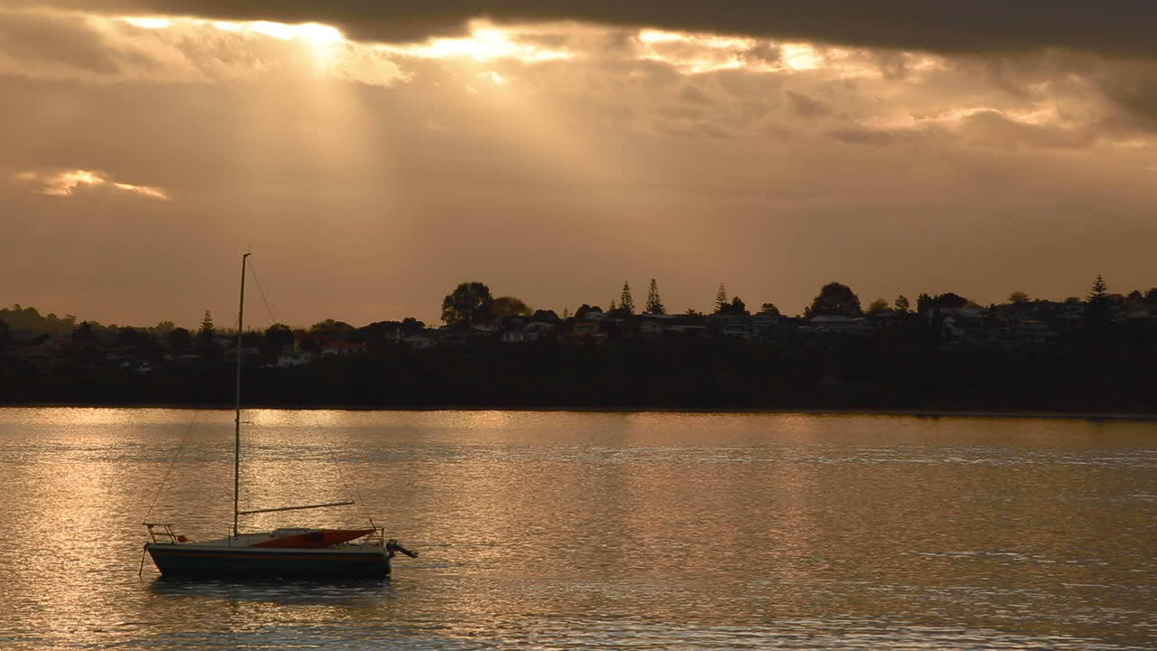 bote pequeño flotando arriba y abajo en un río tranquilo en auckland, nueva zelanda