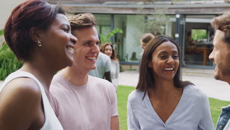 group of multi-cultural friends relaxing and talking in garden together