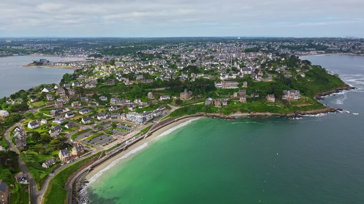 Città costiera di Perros-Guirec, promontorio di Pointe du Chateau, spiaggia di Plage de Trestignel, Bretagna, Francia. Ripresa aerea all'indietro