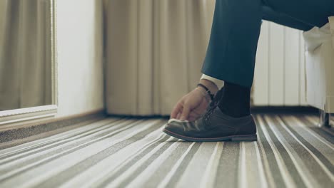 young man cleans his shoes closeup