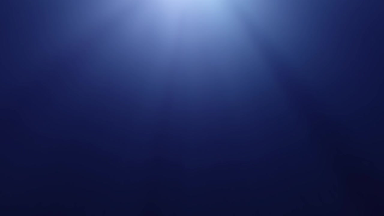 Sun rays underwater in dark blue sea water with copy space