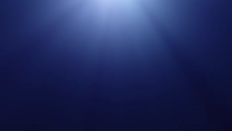 sun rays underwater in dark blue sea water with copy space
