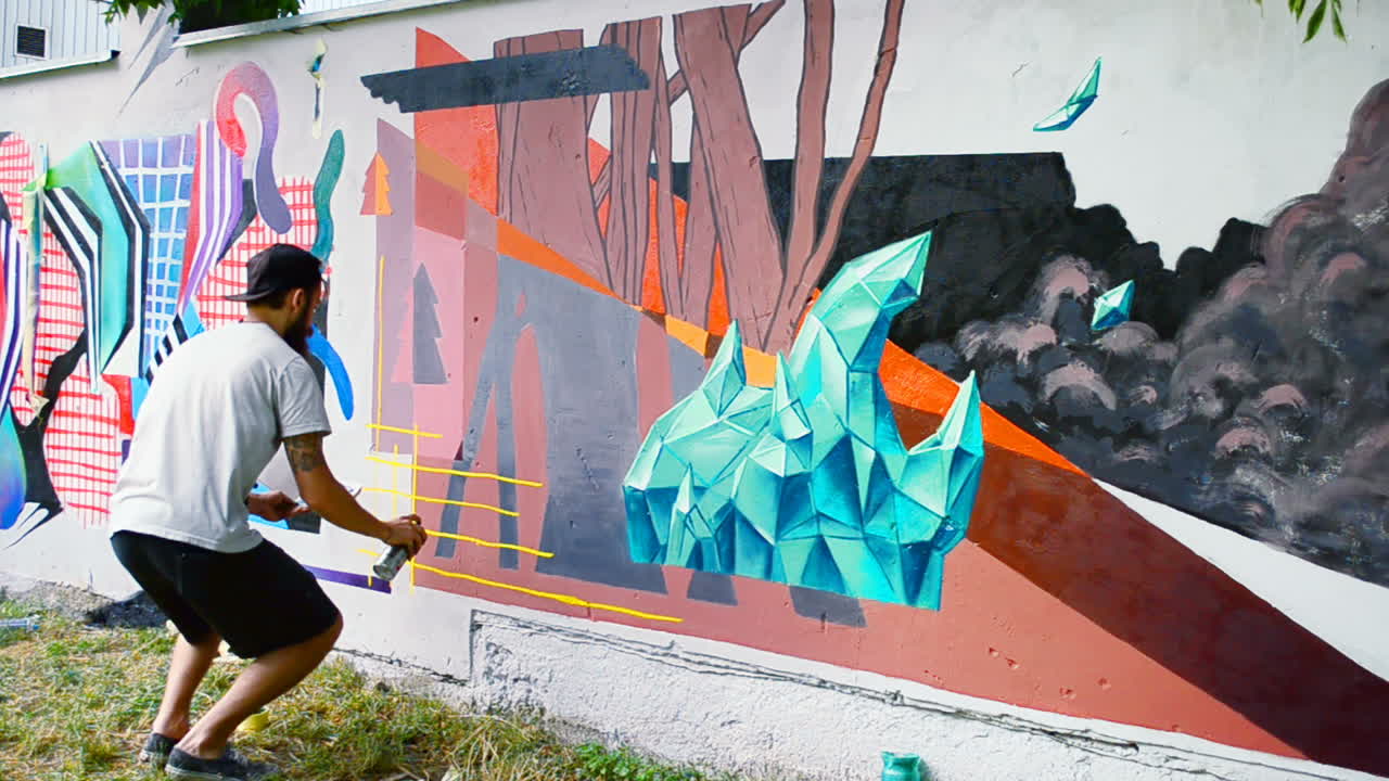 L'artista realizza graffiti su una recinzione. Disegno astratto