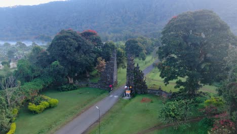 Asphalt-road-leading-through-gates-of-Handara,-aerial-drone-fly-toward-view