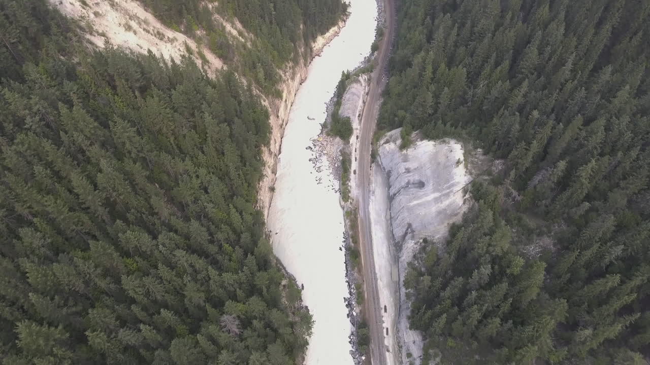 tomas de drones panorámicas de un río y vías de tren que atraviesan un valle humeante en 4k
