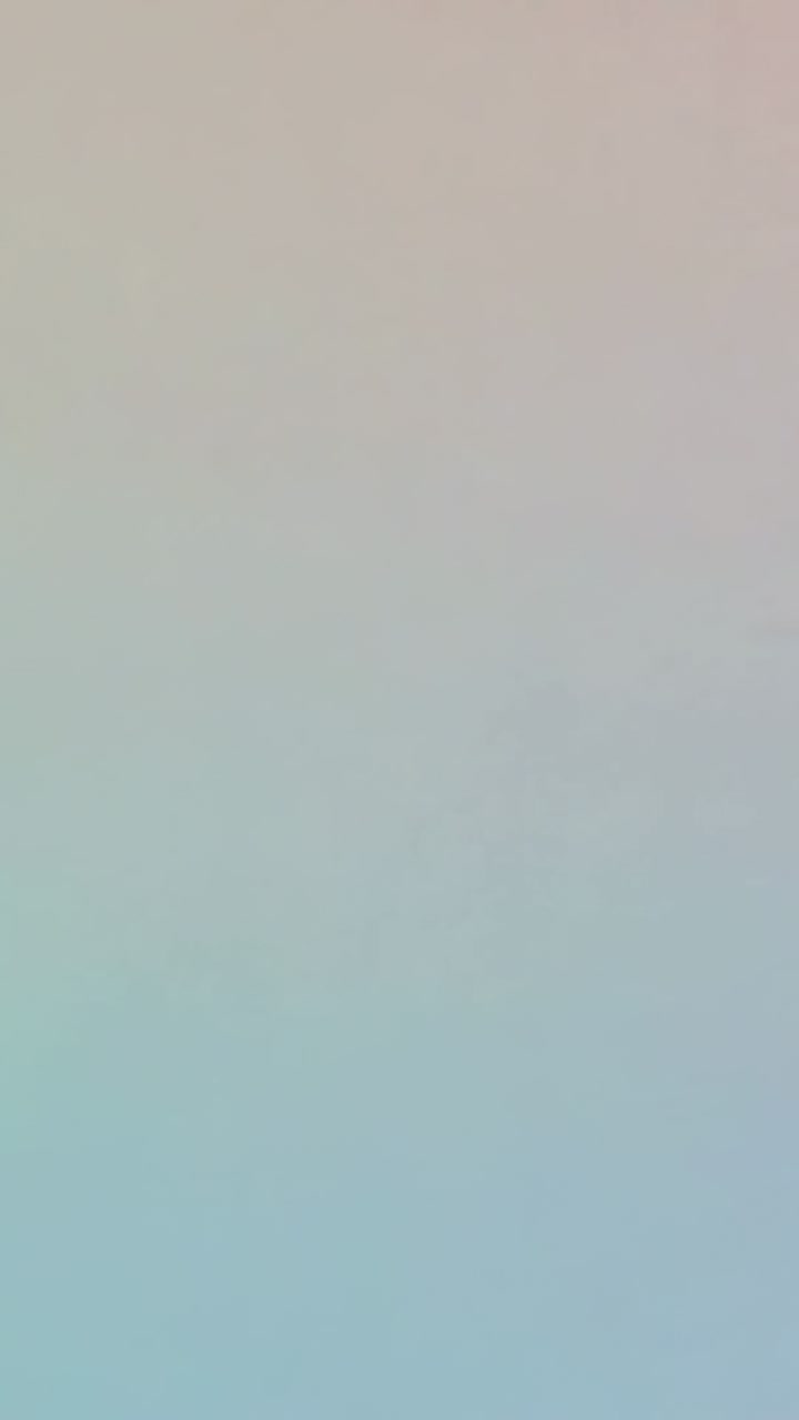 Vertical video: Advancing frames causing pastel gradient cooling on screen pink-to-blue, no objects