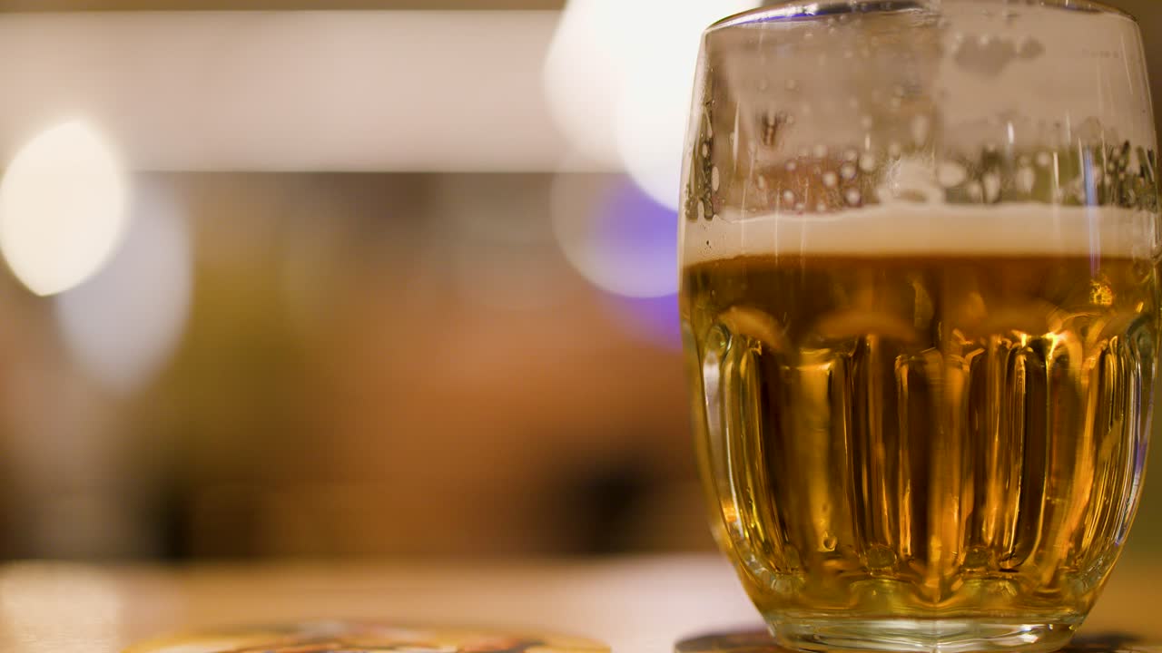 Closeup of foamy lager beer in glass mug at a cozy Czech brewery setting