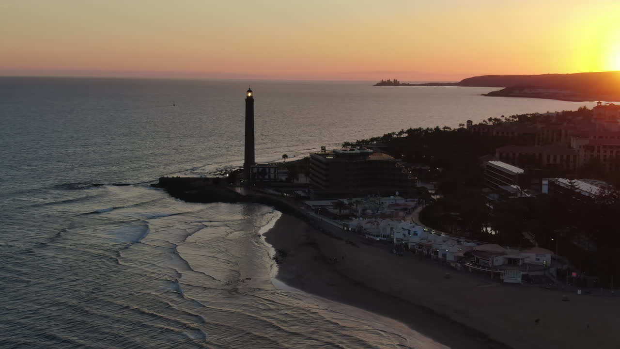 Scenic aerial footage of the Maspalomas lighthouse and coastline during a beautiful sunset in Gran Canaria, Canary Islands. Spain