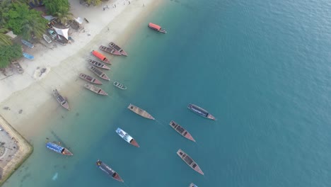 straight down aerial shot of the beach and boats on the coast of stone town in zanzibar, tanzania