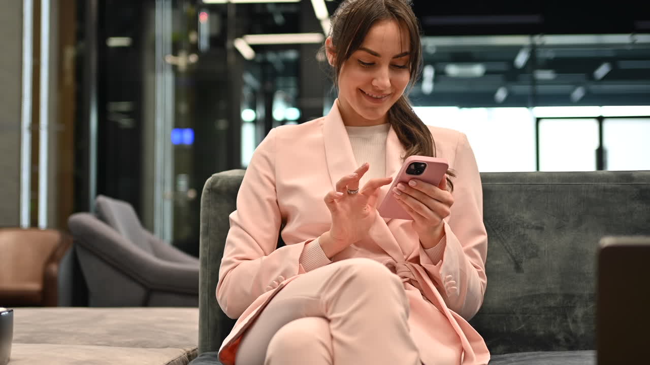 Woman smiling while scrolling through her phone