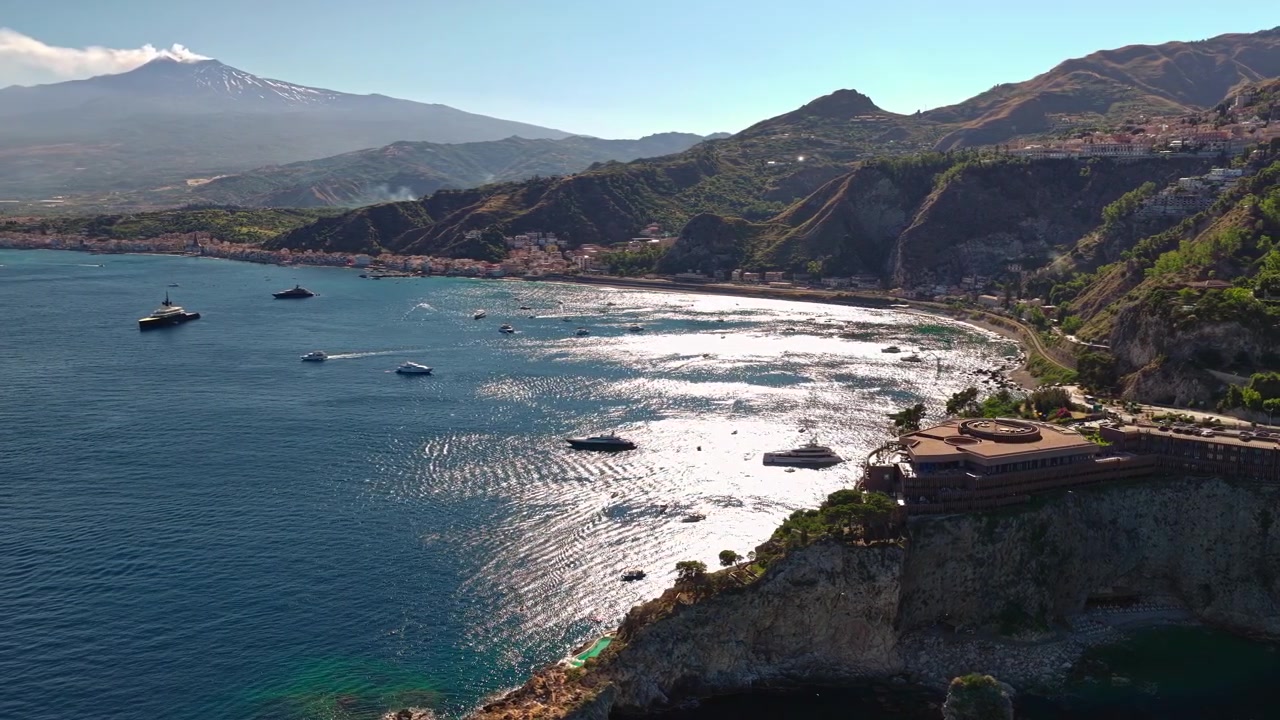 Ripresa aerea con drone della costa di Taormina, Italia Sicilia, strada lungomare e Monte Etna