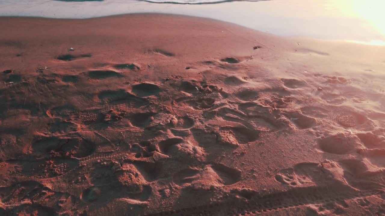 vista desde la arena de la playa inclinándose hacia el horizonte durante la puesta de sol