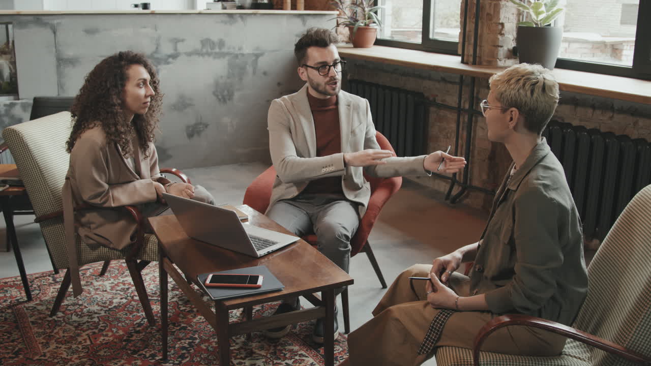 Bearded Businessman Talking to Female Colleagues
