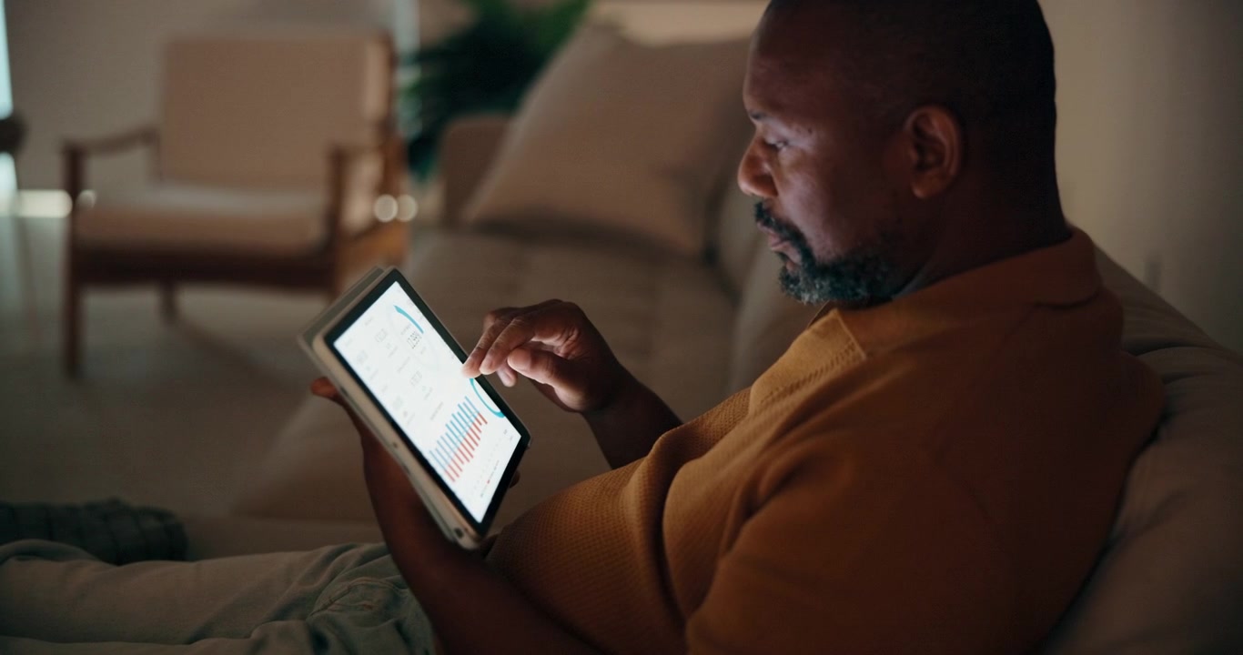 Mature Man Analyzing Financial Data on Tablet at Home