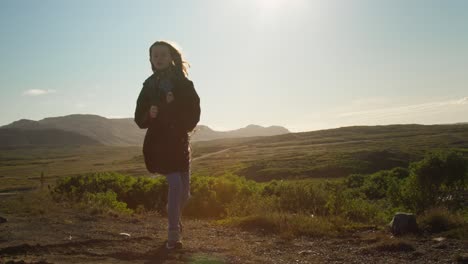 Toma-En-Cámara-Lenta-De-Una-Niña-Caminando-Al-Lado-De-Una-Pista-En-Islandia-En-Un-Día-Ventoso