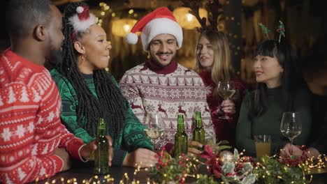 tracking shot approaching group of friends celebrating christmas at a bar