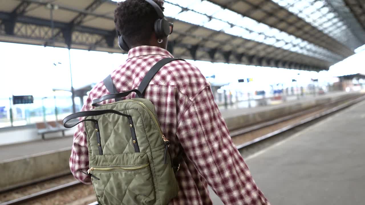 Una persona con uno zaino in una stazione ferroviaria