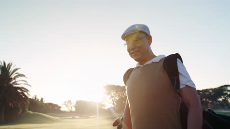 golfer carrying his golf bag