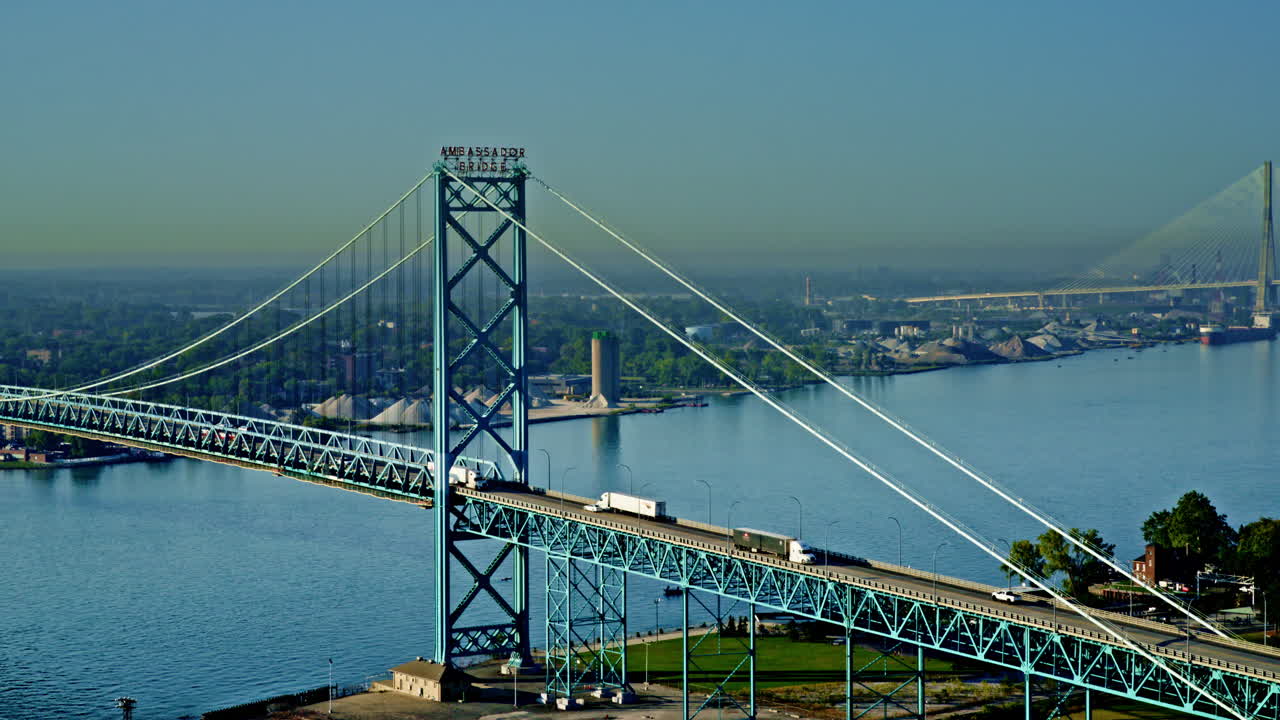 Drone footage sweeping along Detroit River, skyline and freighter sharing the horizon