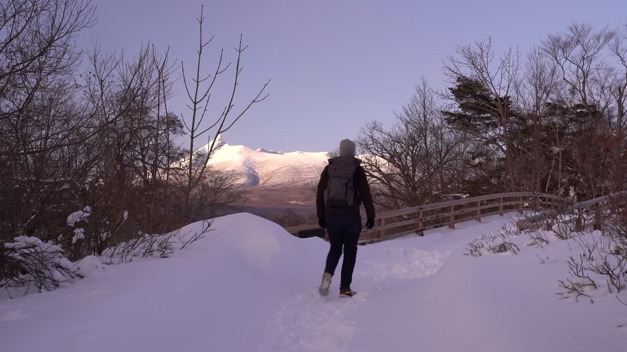 viajero masculino caminando por el paisaje nevado de onuma koen en hokkaido, japón