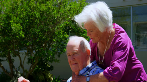 vista lateral de una pareja de ancianos caucásicos activos abrazándose en el jardín del hogar de ancianos 4k