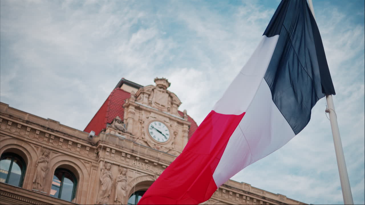 French flag waving in front of the Mairie de Cannes Town hall in Cannes, France