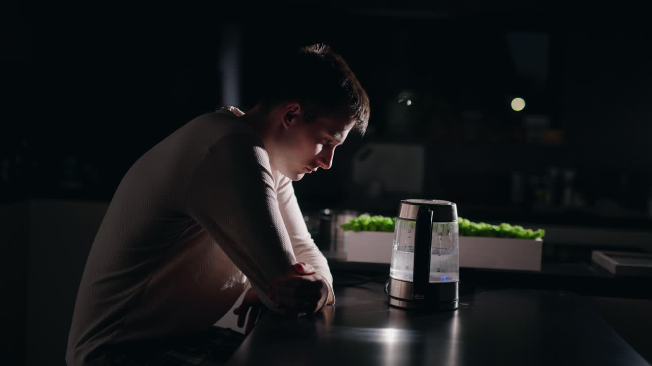 밤에 어두운 부에서 혼자 앉아있는 남자.