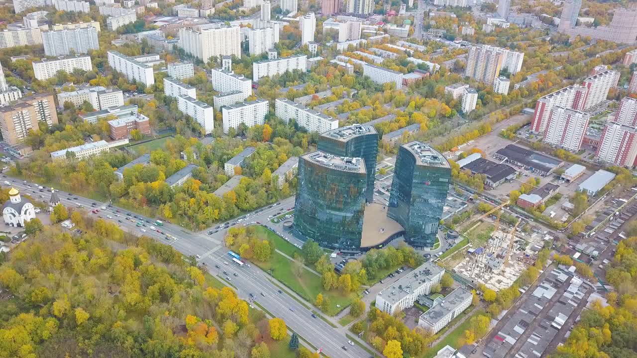 Aerial View of a City with Modern Buildings and Autumn Foliage