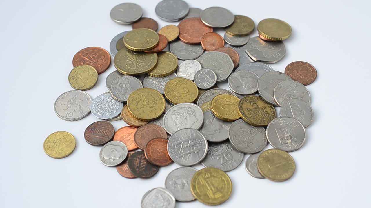 Dinero sobre fondo blanco. Monedas de distintos países del mundo