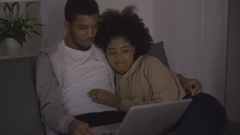pareja joven viendo una película en la computadora portátil 1