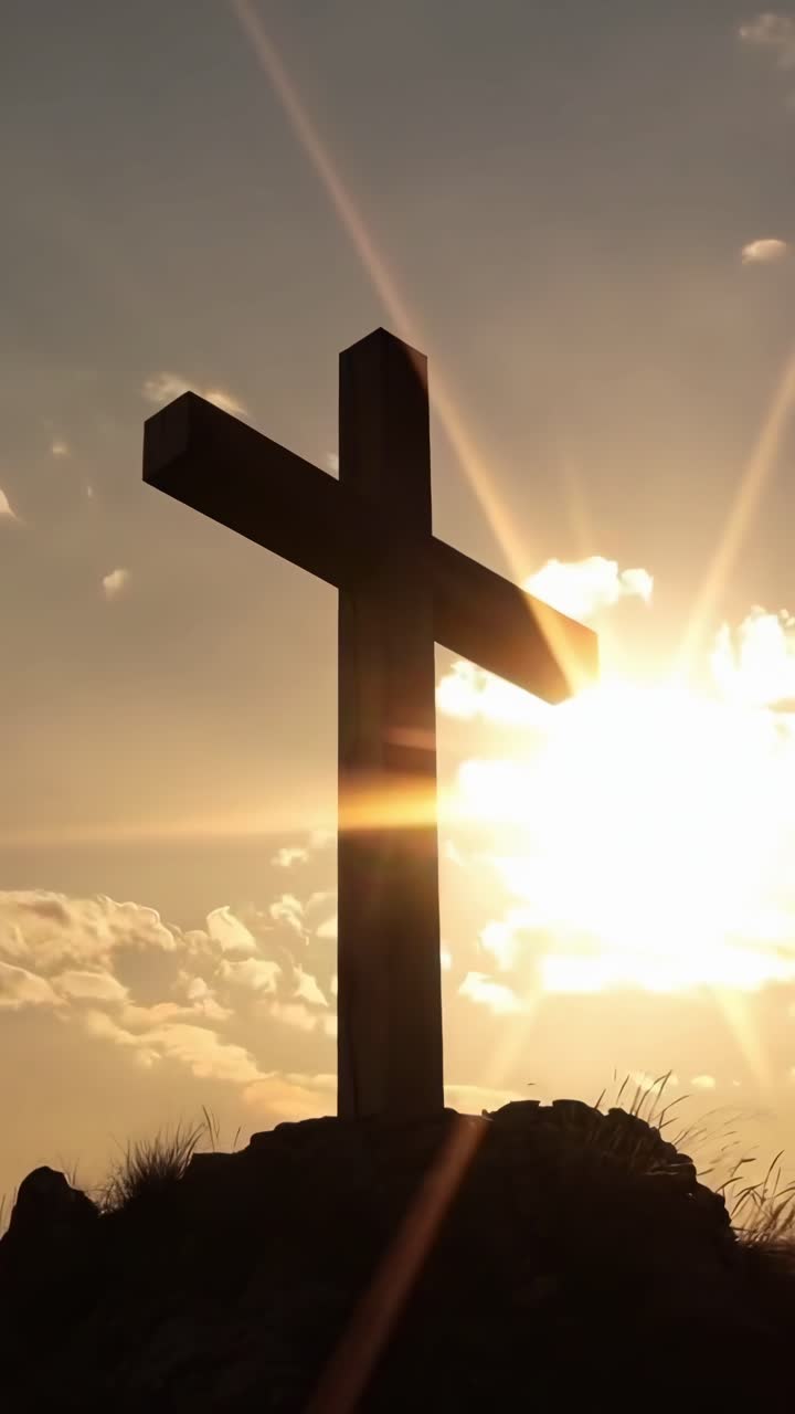 Silhouette di una croce al tramonto, ripresa dal basso. Drammatica e serena, ideale per video