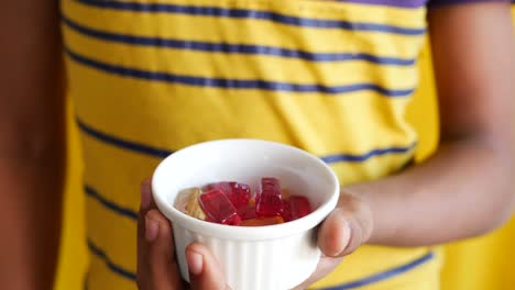 child holding a bowl of gummy candies