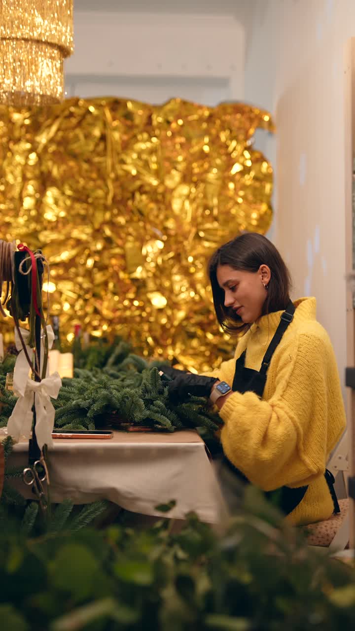 una mujer haciendo una corona de navidad.