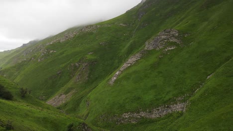 A-fresh-green-mountain-valley-with-chilly-clouds-forming-at-the-peak