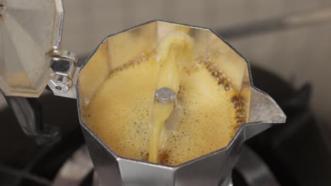 bubbling moka pot releasing fresh coffee in slow motion from the spout