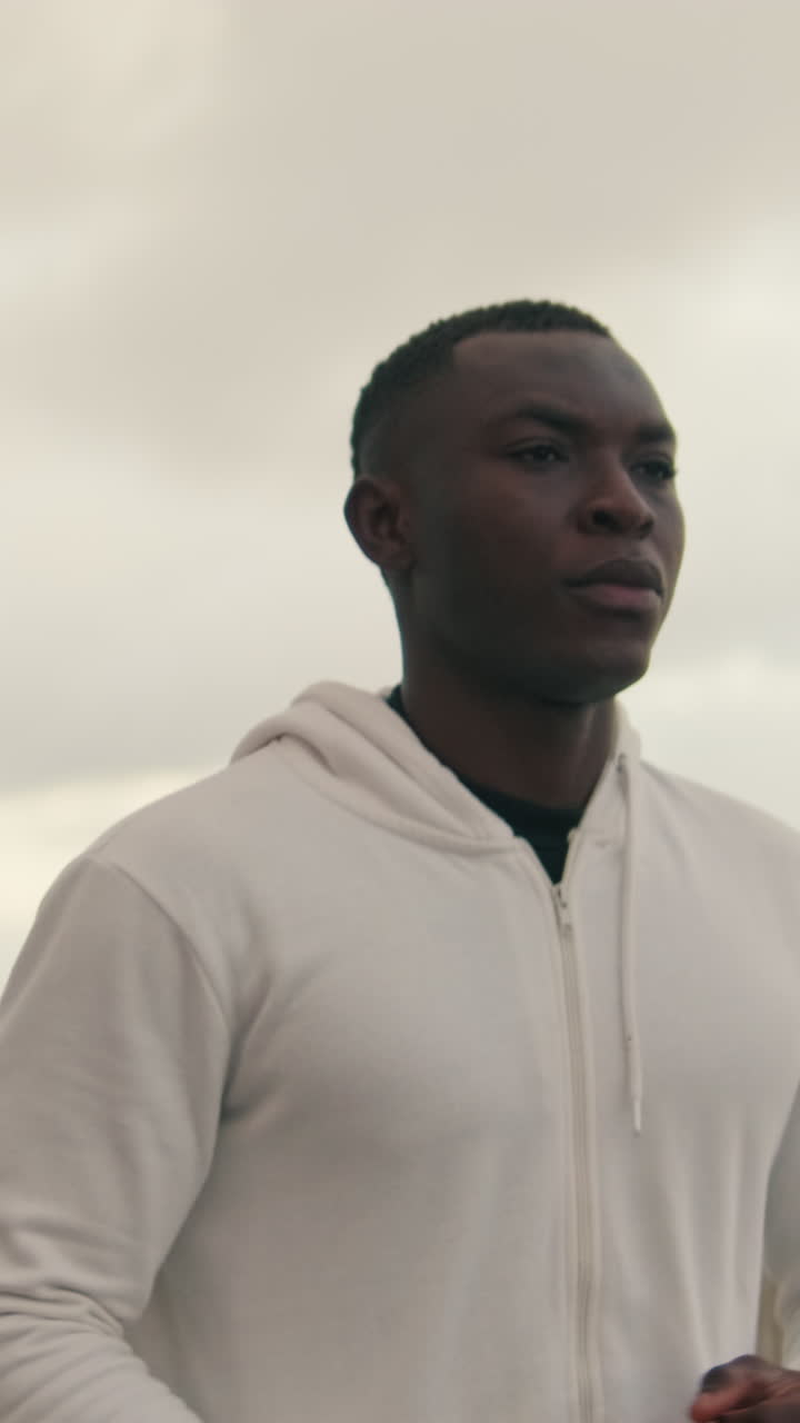 Young African American Man Running Outdoors in White Hoodie