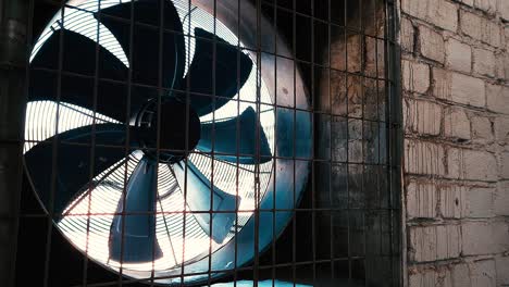 big fan in white brick wall of industrial plant. ventilation of building.