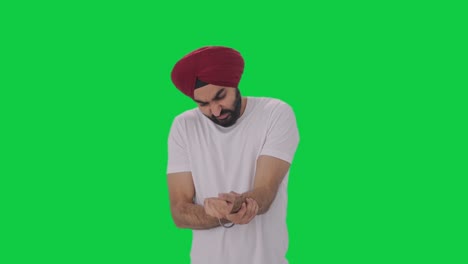 sick sikh indian man suffering from hand pain green screen