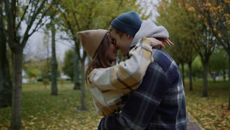 jóvenes amantes besándose románticamente en el parque de otoño