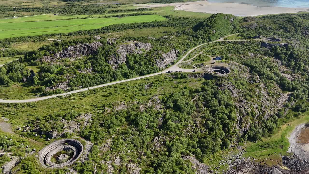 Aerial footage of Batterie Dietl on Engeløya, Norway. A historic World War II site now set on a peaceful island, surrounded by mountains and lapped by the sea