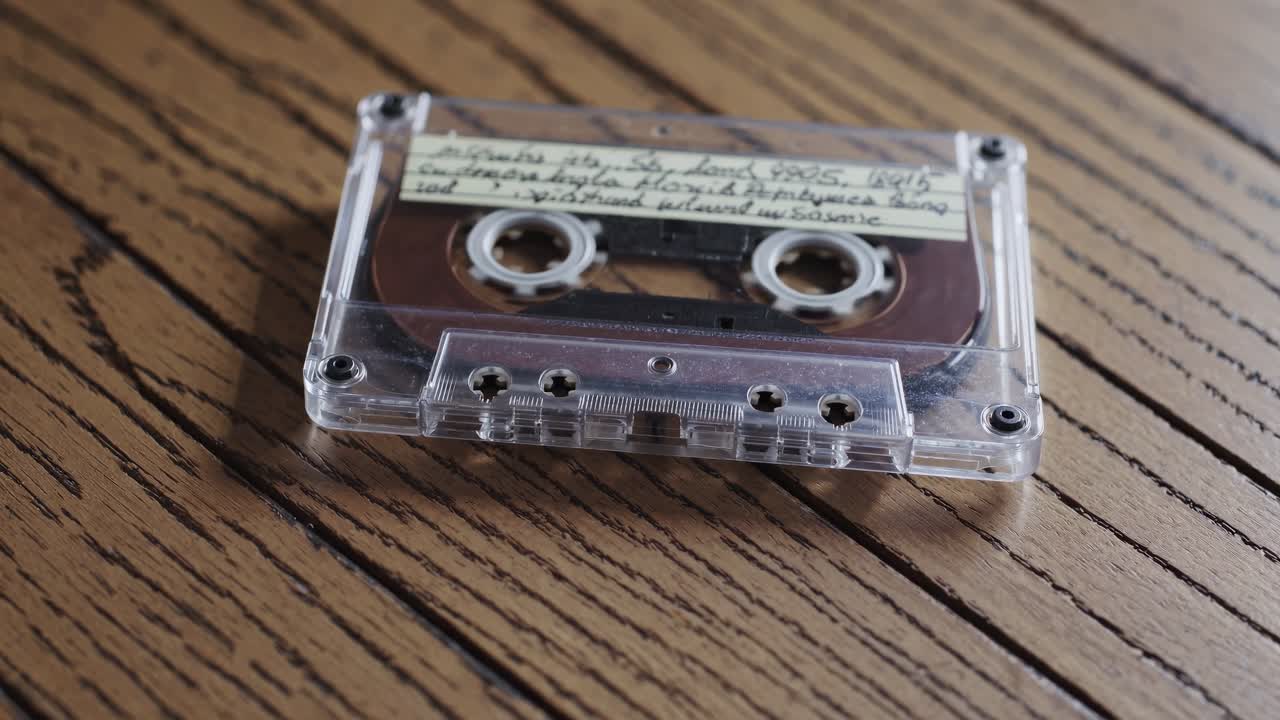Close-up of a vintage cassette tape on a wooden table, captured from a low angle