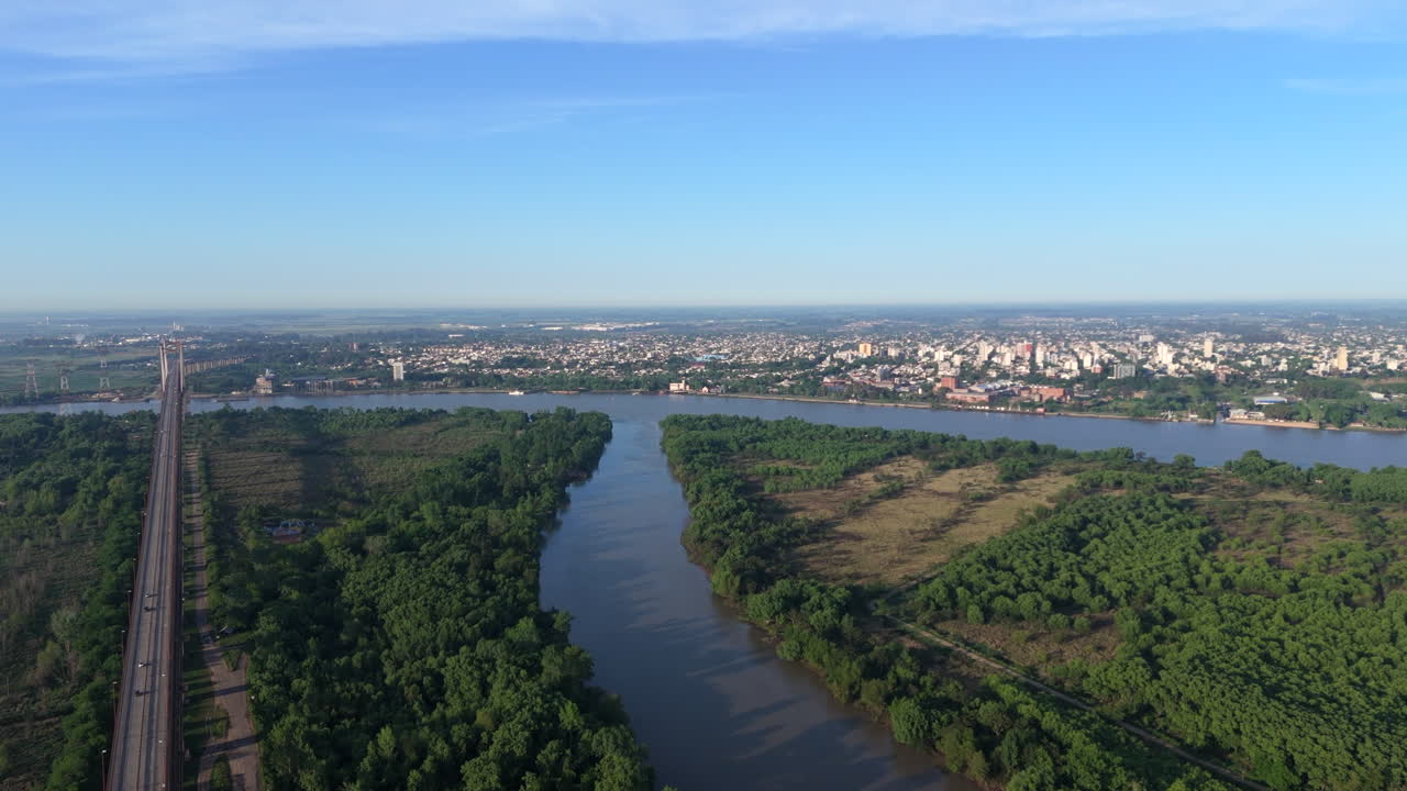 Aerial view of suspension bridge Zárate Brazo Largo over Paraná River with city in background, Argentina