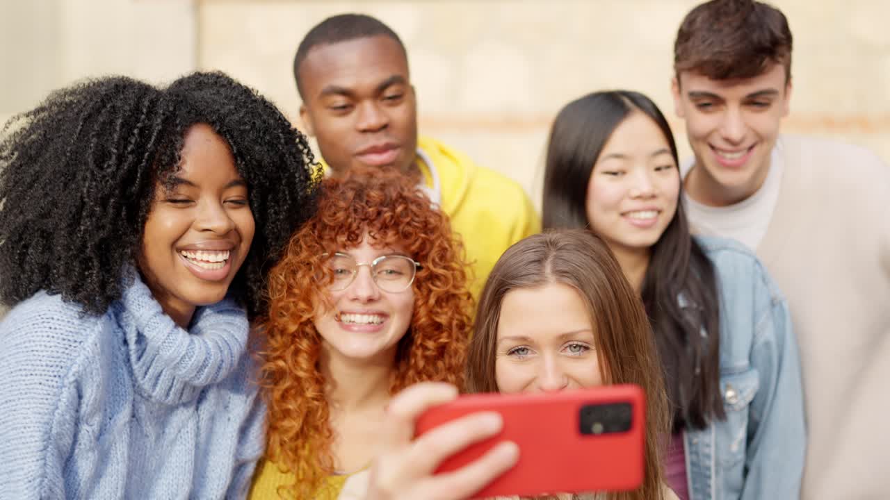 Diverse teenager people taking a selfie smiling and laughing outdoors